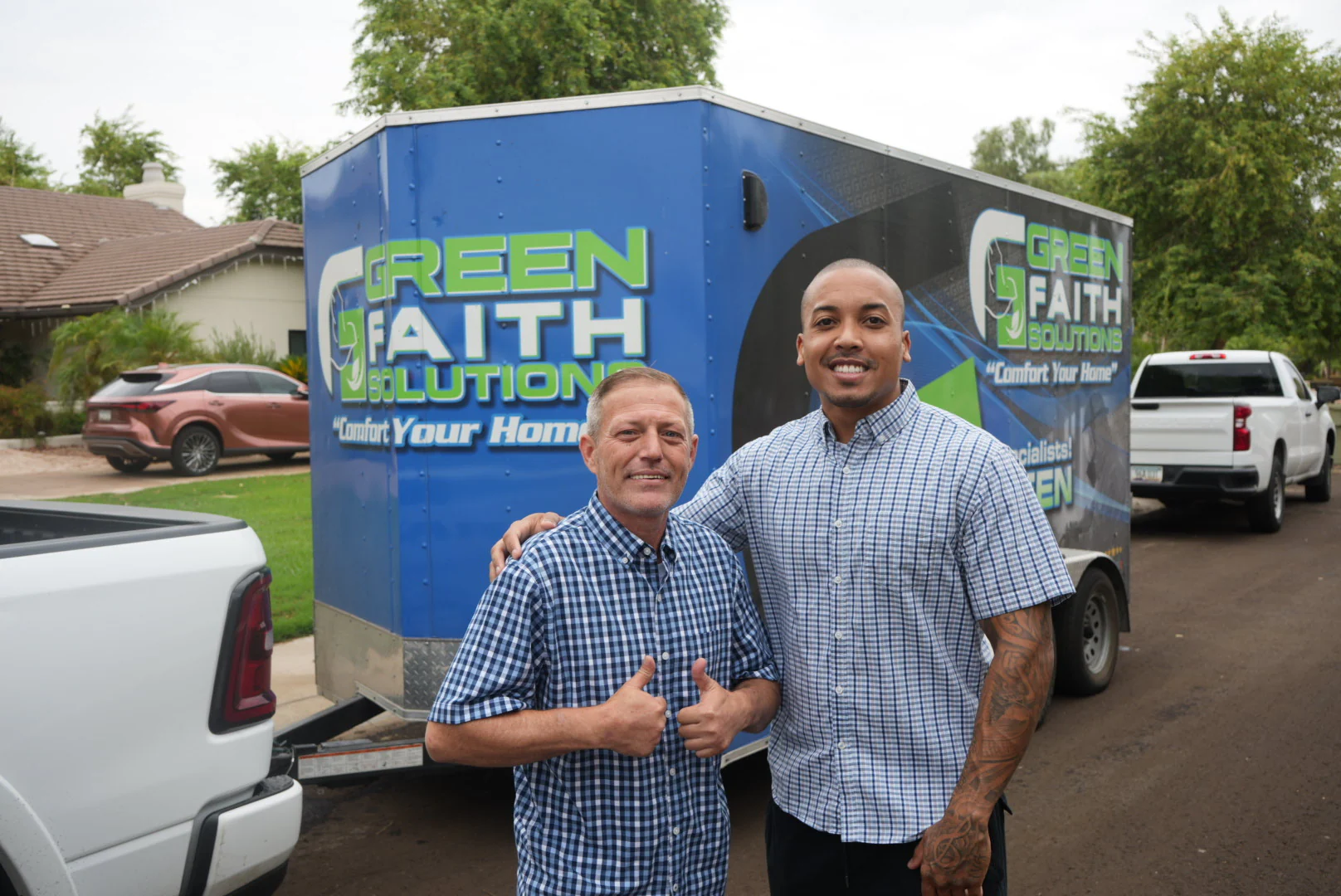 Green Faith Solutions team members standing beside their insulation trailer