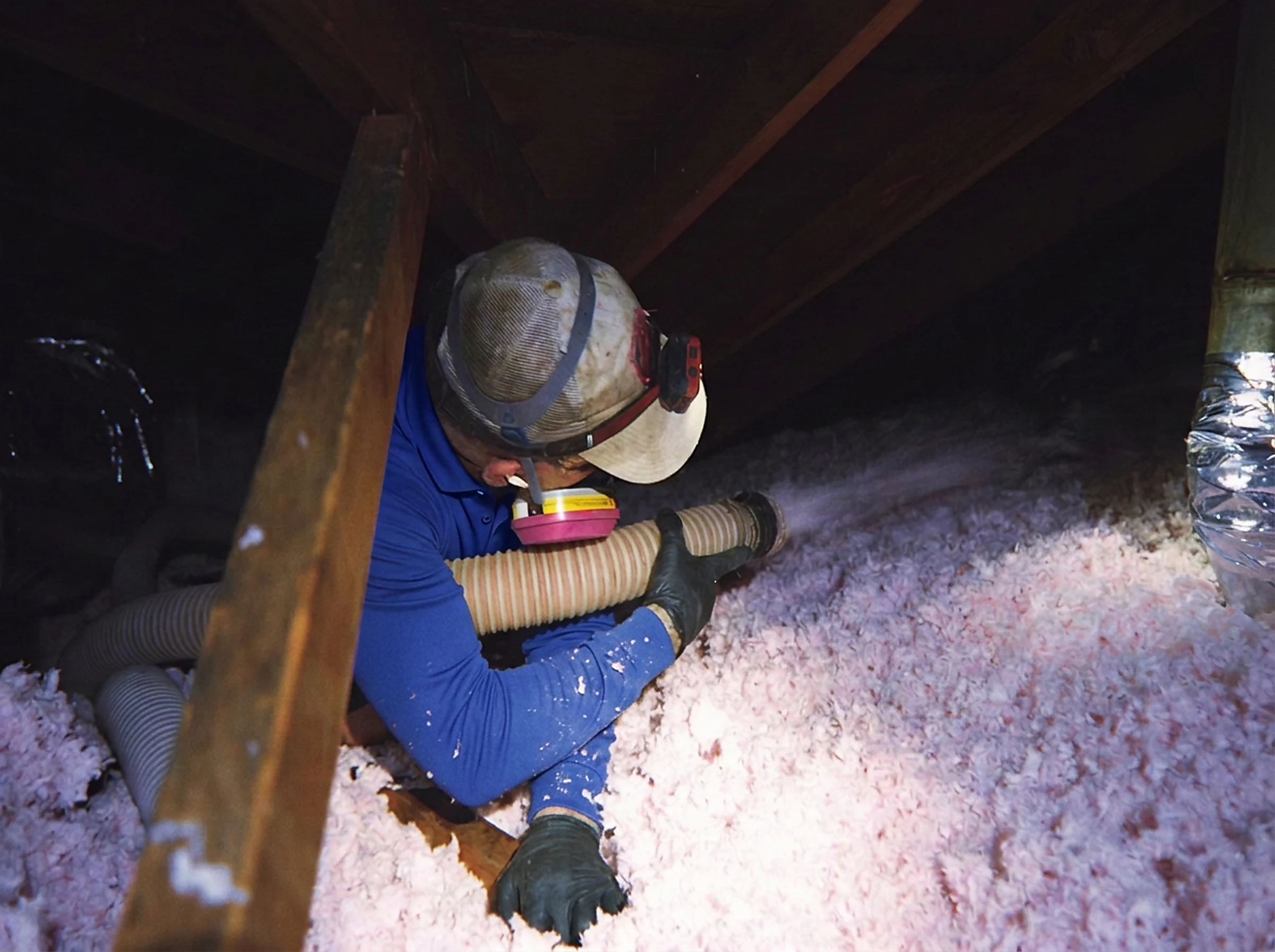 Green Faith Solutions installer distributing insulation around attic framing
