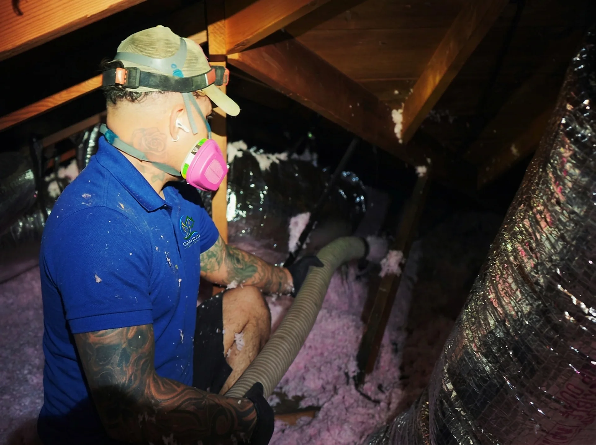 Green Faith Solutions team member working in an attic with protective equipment