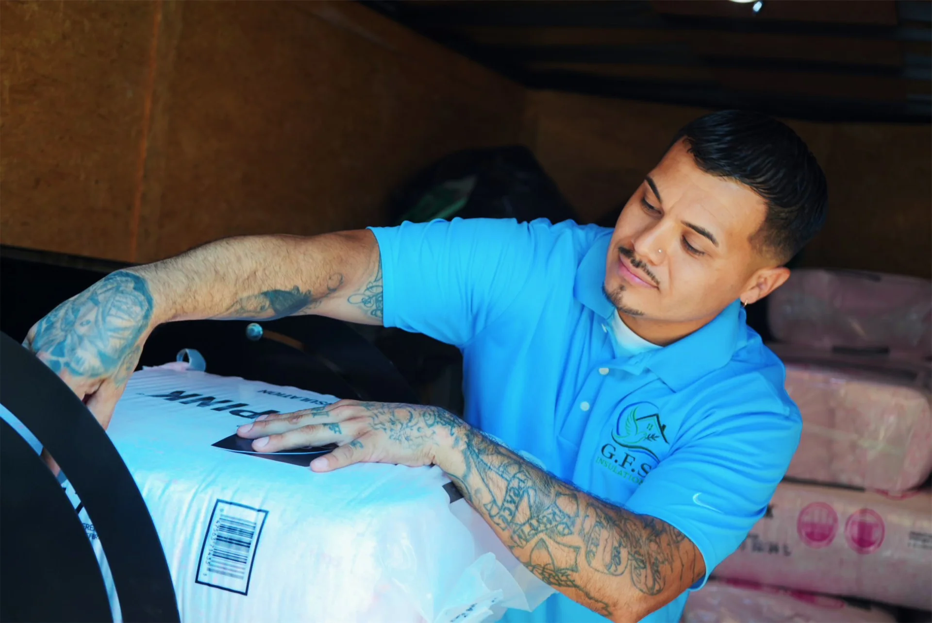 Green Faith Solutions crew member loading insulation equipment