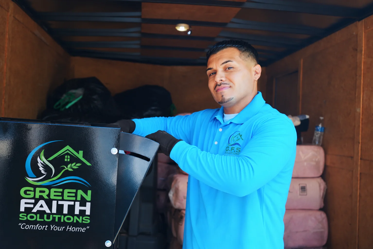 Green Faith Solutions installer preparing insulation equipment in an attic