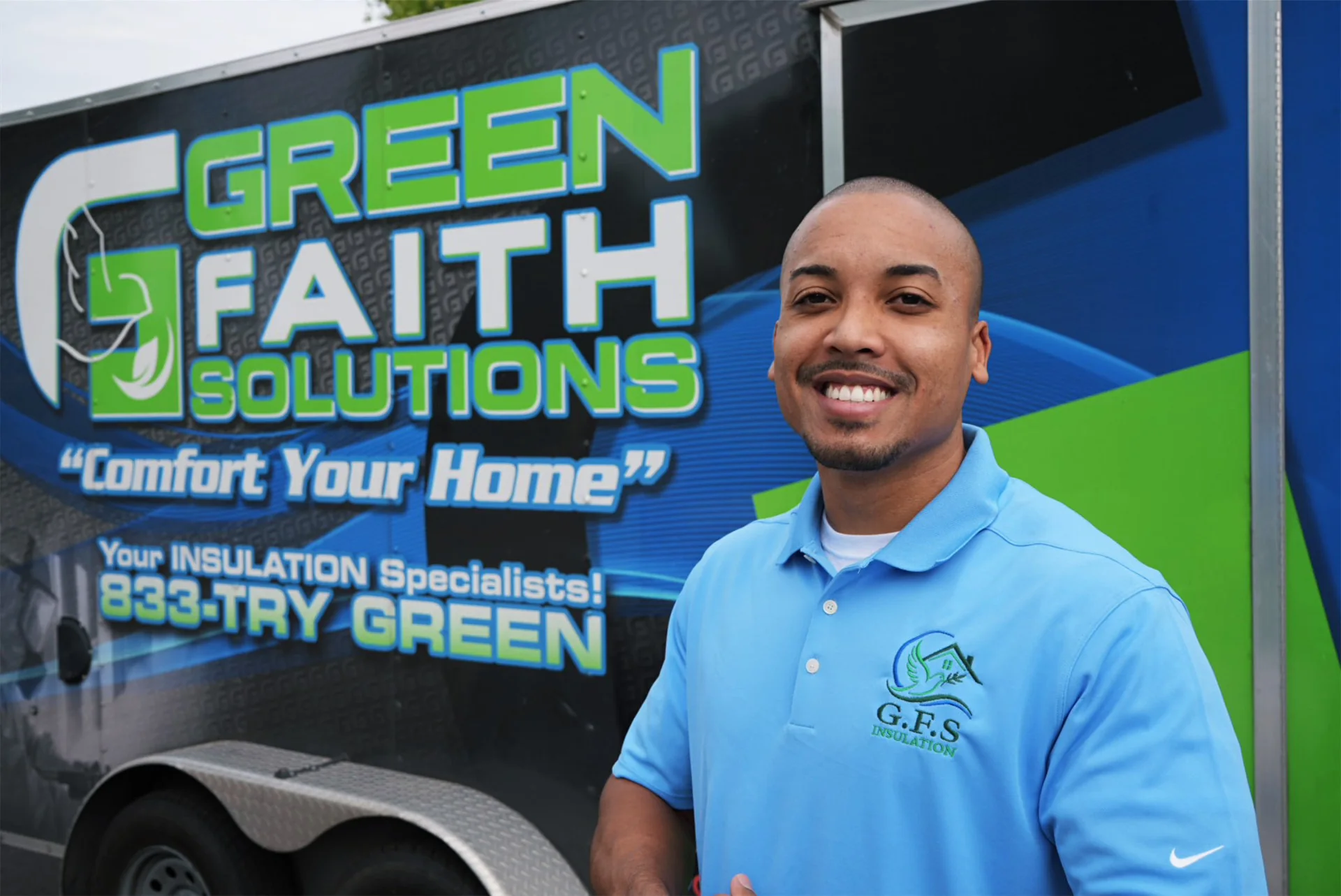 Green Faith Solutions team member beside the branded trailer
